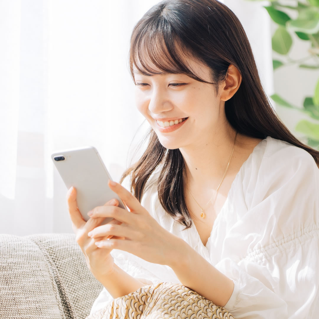 スマフォで美容外科を探している女性
