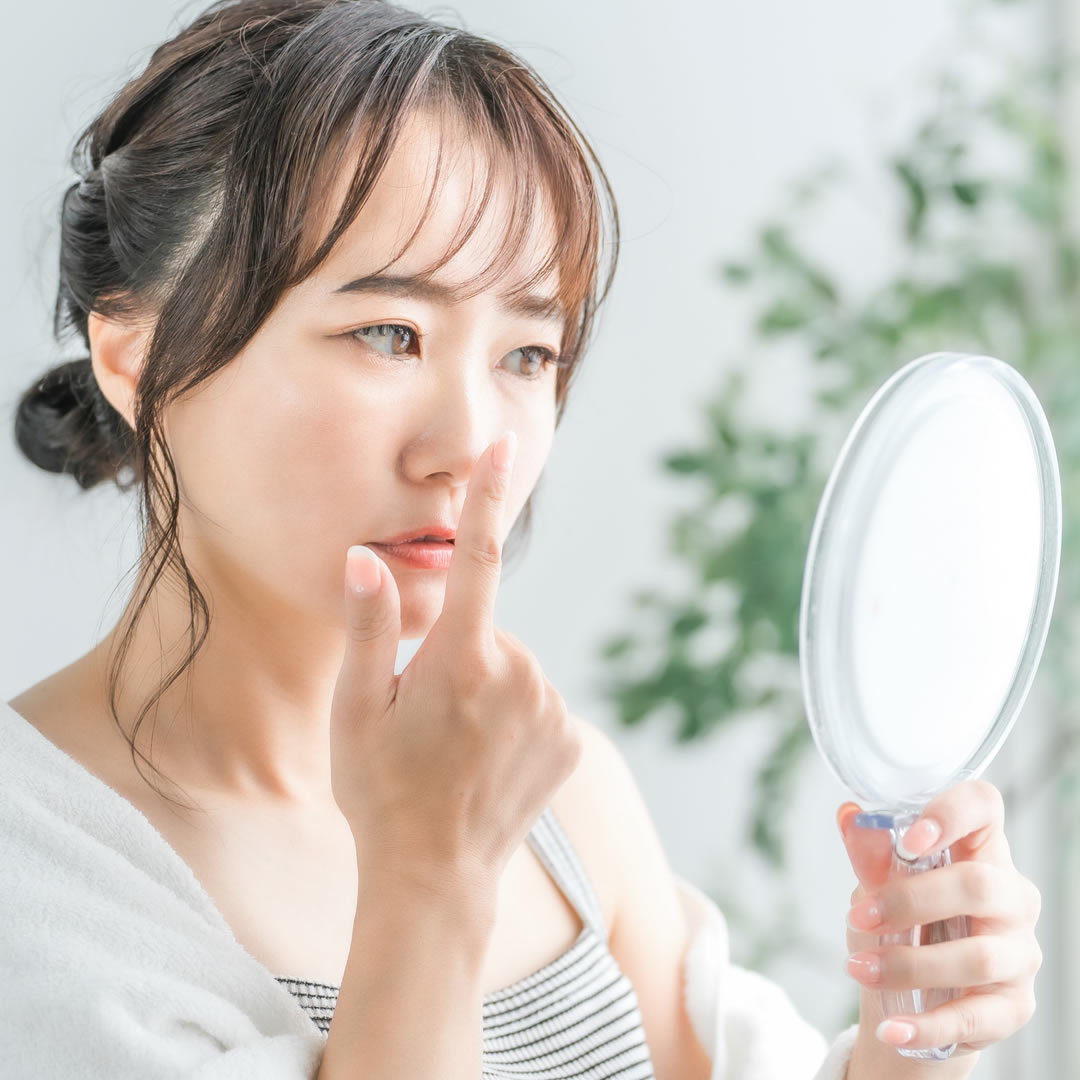 鼻先を手で押している女性